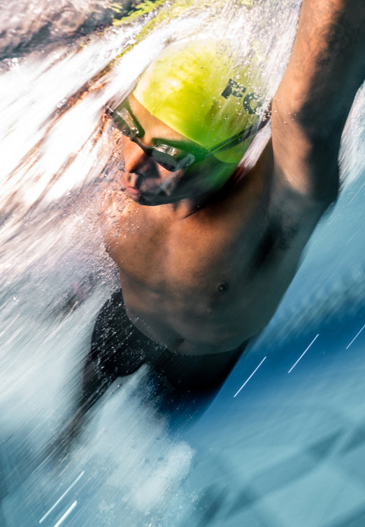 Man swimming underwater with smart swim goggles