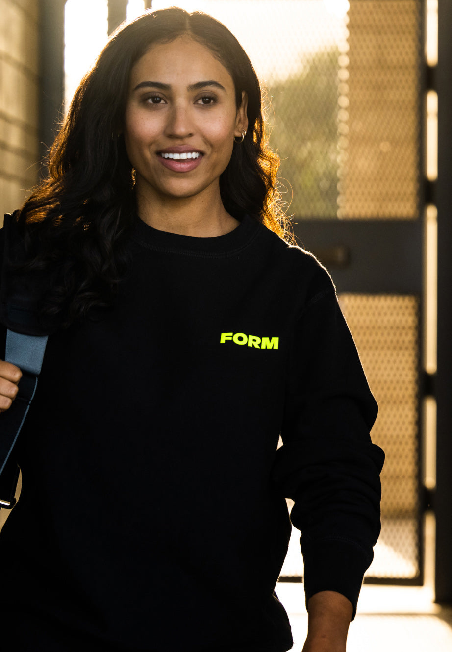 Woman wearing black FORM Swim sweater after a guided swim workout