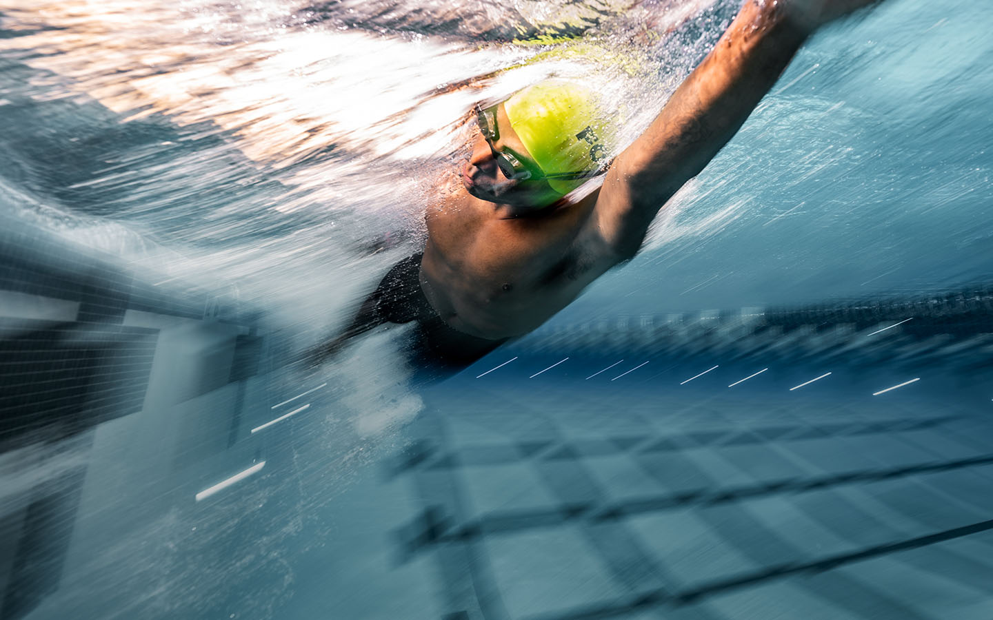 Man doing front crawl with a swimming heart rate monitor in his goggles